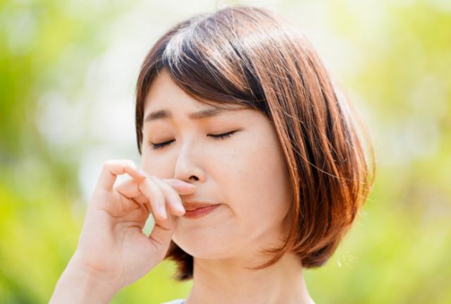 花粉症で鼻詰まりを感じる女性